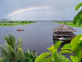 Lais Puzzle - Blick auf den Nebenfluss des Amazonas in Iquitos, Peru. Ein Regenbogen über dem Fluss und ein wunderschönes Gebäude, das auf dem Wasser schwimmt - 500 & 1.000 Teile