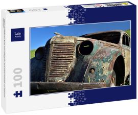 Lais Puzzle - Altes verrostetes Auto mit rostigem Lack ohne Fenster vor blauem Himmel - 100 Teile