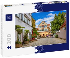 Lais Puzzle - Gemütliche Straße in der malerischen bayerischen Stadt Lindau am Bodensee in Deutschland. Traditionelle alte deutsche Häuser mit Cafe. Sonniger Sommertag. - 200 Teile