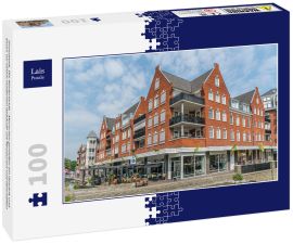 Lais Puzzle - Groesbeek, Die Niederlande - Menschen genießen ein Getränk und Essen vor einem modernen Gebäude mit Restaurant und Geschäften - 100 Teile