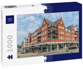 Lais Puzzle - Groesbeek, Die Niederlande - Menschen genießen ein Getränk und Essen vor einem modernen Gebäude mit Restaurant und Geschäften - 1.000 Teile