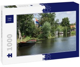 Lais Puzzle - Ruderboot im Fluss, mit Häusern, Bäumen und Brücke. Broek op Langedijk, Niederlande - 1.000 Teile
