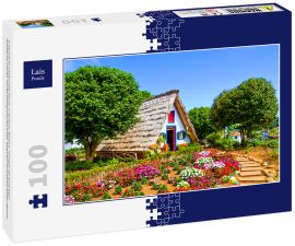 Lais Puzzle - Erstaunliche traditionelle Häuser in Santana, Madeira, Portugal. Die dreieckigen Holzhäuser sind ein Teil des portugiesischen Erbes. Vorgarten mit schönen bunten Blumen - 100 Teile