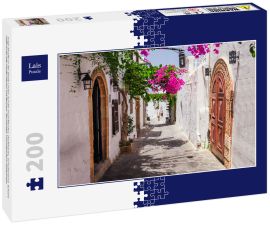 Lais Puzzle - Enge Straße in der Stadt Lindos auf der Insel Rhodos, Dodekanes, Griechenland. Schöne malerische alte weiße Häuser mit Blumen. Berühmtes Touristenziel in Südeuropa - 200 Teile