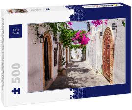 Lais Puzzle - Enge Straße in der Stadt Lindos auf der Insel Rhodos, Dodekanes, Griechenland. Schöne malerische alte weiße Häuser mit Blumen. Berühmtes Touristenziel in Südeuropa - 500 Teile