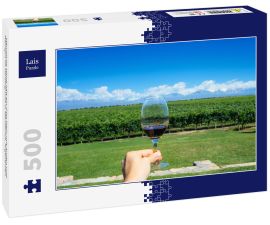 Lais Puzzle - Männliche Hand hält ein Glas Wein mit Anden und Weingut im Hintergrund in Mendonza, Argentinien - 500 Teile