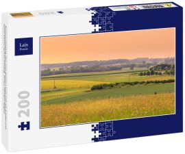 Lais Puzzle - Sonnenuntergang über einer grünen Landschaft mit Schafen und einem kleinen Dorf im Frühling. Tienen, Flandern Belgien - 200 Teile